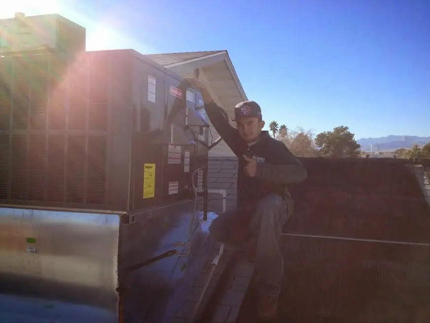 HVAC technician performing AC Tune-Up on a rooftop unit in Elk Ridge